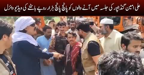 Ali Amin Gandapur distributing money among jalsa participants