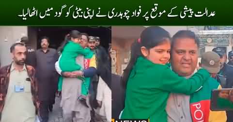 Fawad Chaudhry carries her daughter in his arms while appearing in court