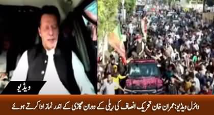 Imran Khan offering prayer in his car during PTI Rally