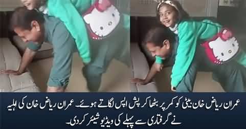 Imran Riaz Khan doing push-ups with his daughter sitting on his back