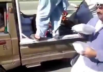 People loot food boxes as PML-N organisers try to carry them safely to the Jalsagah